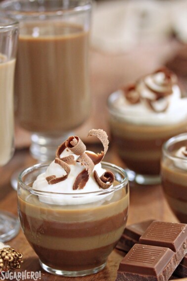 Layered Coffee Panna Cotta in glass cups with whipped cream and chocolate curls on top.