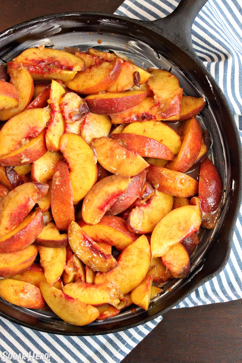Cast iron skillet filled with sliced peaches
