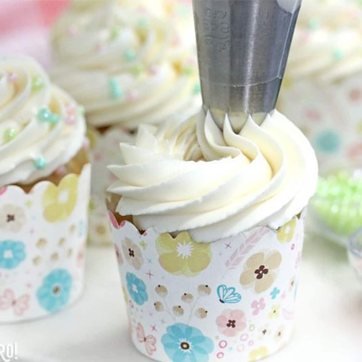 A swirl of the Easiest Swiss Meringue Buttercream being piped onto a cupcake.