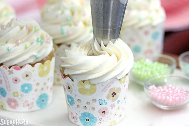This is the Easiest Swiss Meringue Buttercream recipe you’ll ever make! Once you try it, you’ll want to use it to cover all of your cakes and cupcakes. | From SugarHero.com The Easiest Swiss Meringue Buttercream - A picture displaying the buttercream being piped. | From SugarHero.com