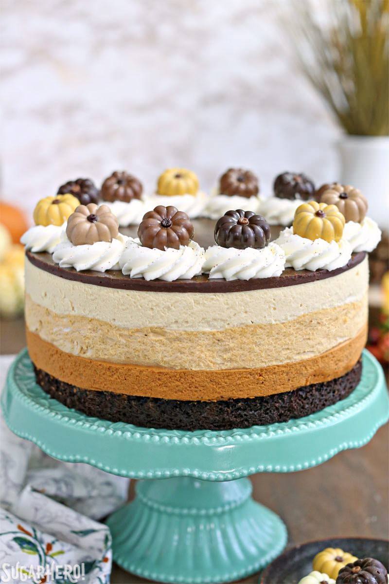 Pumpkin Chocolate Mousse Cake - a stunning 4-layer dessert with chocolate cake, cinnamon mousse, pumpkin-butterscotch mousse, and salted caramel mousse! | From SugarHero.com Pumpkin Chocolate Mousse Cake - A straight shot of the cake displayed on cake stand. | From SugarHero.com