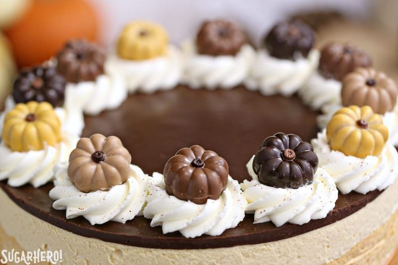 Pumpkin Chocolate Mousse Cake - A stunning 4-layer dessert with chocolate cake, cinnamon mousse, pumpkin-butterscotch mousse, and salted caramel mousse! Finished with a layer of shiny chocolate ganache and whipped cream, it’s a total show stopper! | From SugarHero.com Pumpkin Chocolate Mousse Cake - Close up of the top of the cake. | From SugarHero.com