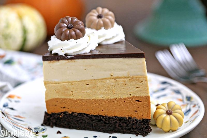 Pumpkin Chocolate Mousse Cake - A stunning 4-layer dessert with chocolate cake, cinnamon mousse, pumpkin-butterscotch mousse, and salted caramel mousse! Finished with a layer of shiny chocolate ganache and whipped cream, it’s a total show stopper! | From SugarHero.com Pumpkin Chocolate Mousse Cake - A close up of a slice of cake. | From SugarHero.com