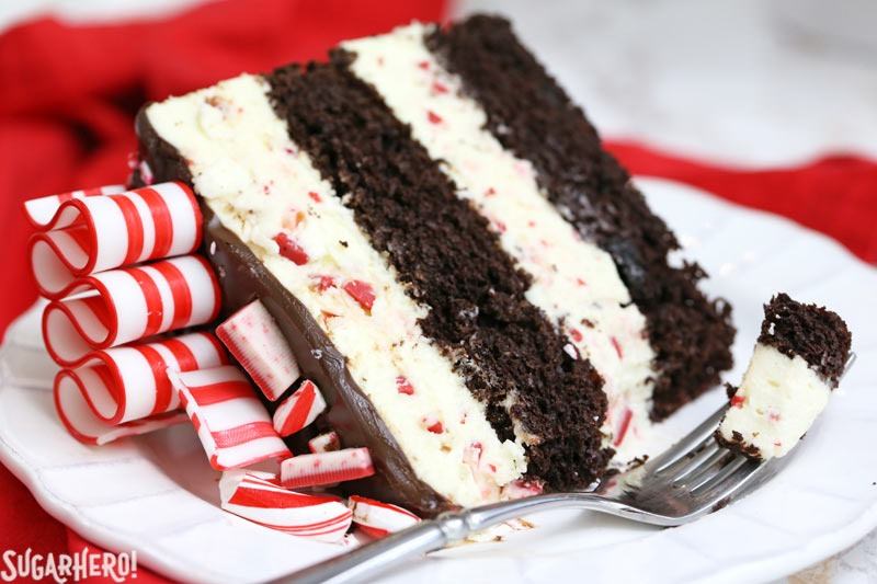 Slice of Candy Cane Mousse Cake on a white plate with a bite taken out of it