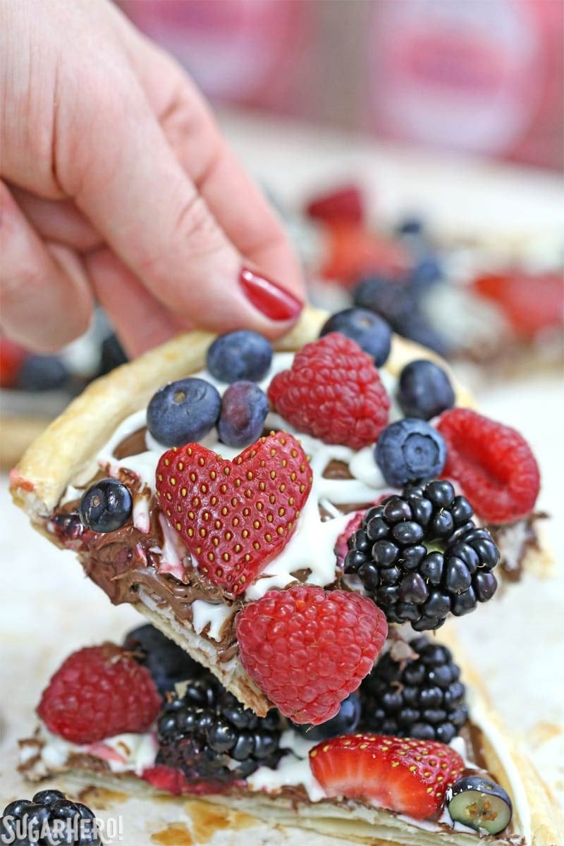 Nutella Puff Pastry Pizza is easy and gourmet. You’ll love the combination of buttery puff pastry, Nutella, white chocolate, and juicy fresh berries! | From SugarHero.com