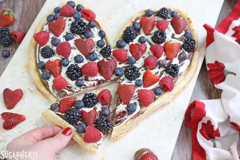 Nutella Puff Pastry Pizza is easy and gourmet. You’ll love the combination of buttery puff pastry, Nutella, white chocolate, and juicy fresh berries! | From SugarHero.com