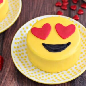 Close-up of heart-eyed Emoji Cake on a yellow polka dot plate.