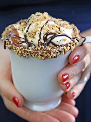 Hands holding a white mug filled with Nutella hot chocolate