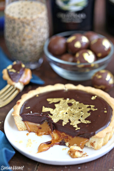 Bailey's Chocolate Caramel Tarts on white plate with bottle of Baileys behind it