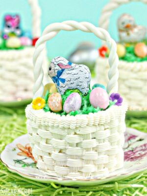 Cupcake decorated with white buttercream to look like an Easter basket, on a bed of edible Easter grass.