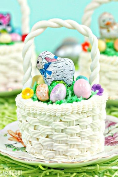 Cupcake decorated with white buttercream to look like an Easter basket, on a bed of edible Easter grass.