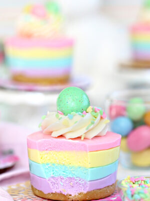 Easter no-bake mini cheesecake topped with frosting, sprinkles and a candy egg.