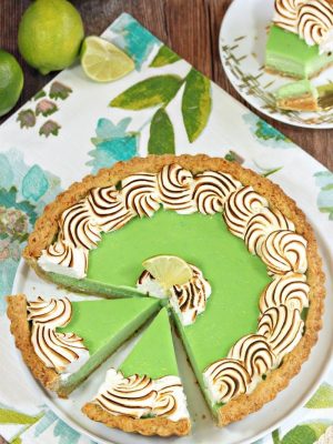 Top view of a Toasted Coconut Lime Meringue Tart on a white plate and floral placemat.