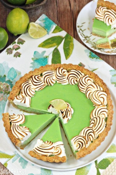 Top view of a Toasted Coconut Lime Meringue Tart on a white plate and floral placemat.