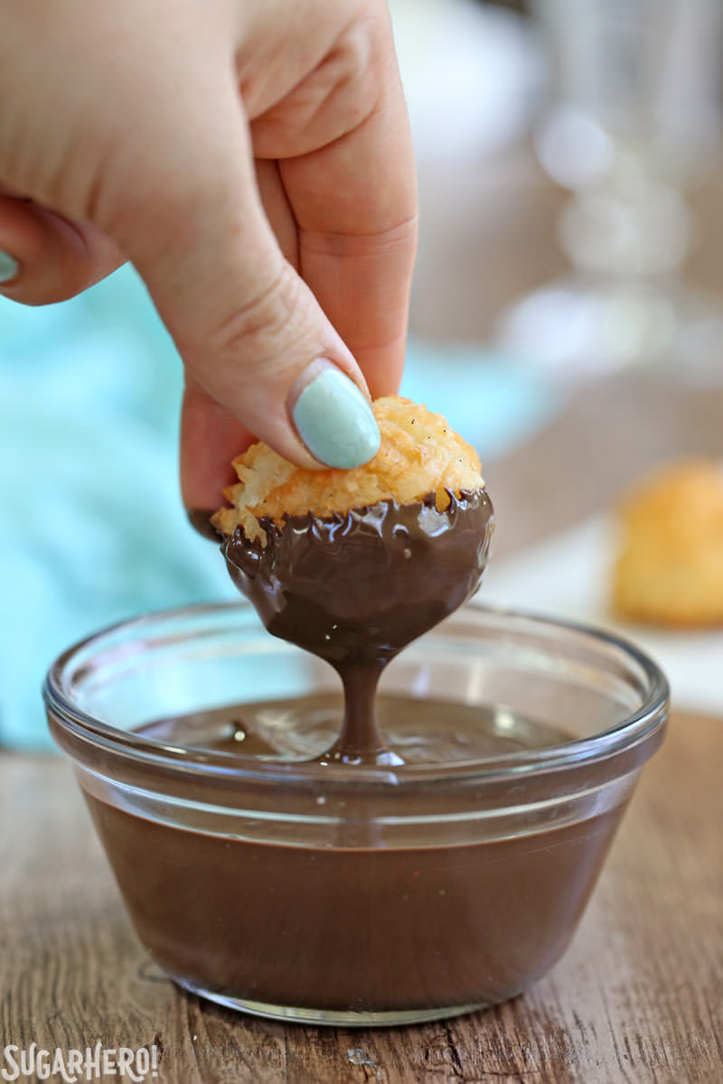 Coconut Macaroons - gluten-free coconut cookies being dunked in rich semi-sweet chocolate. | From SugarHero.com