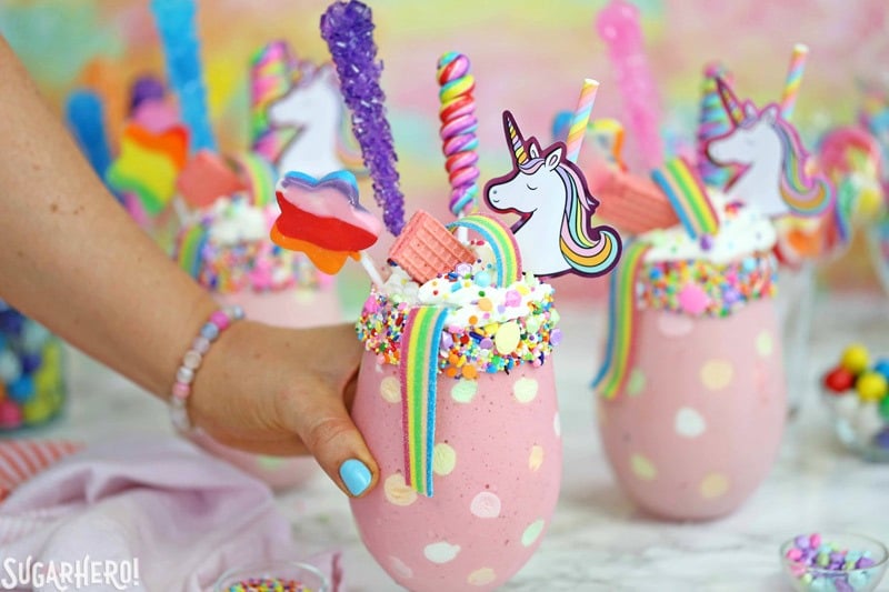 Unicorn Milkshakes - strawberry milkshakes topped with a magical assortment of rainbow candies and treats! | From SugarHero.com Unicorn Milkshakes - try this fun strawberry milkshake topped with rainbow candies! | From SugarHero.com