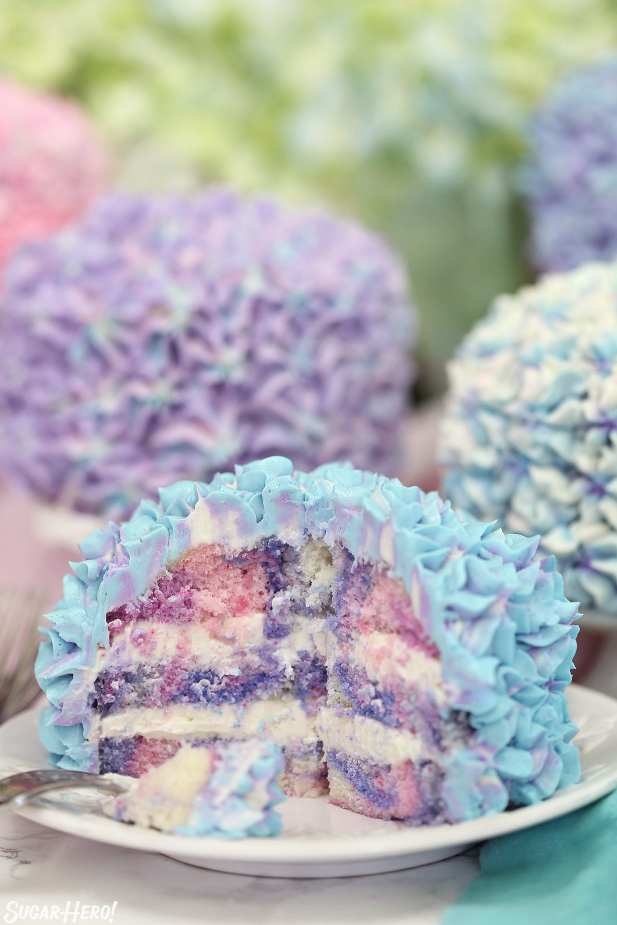 Hydrangea Cakes - A cake with bites take out showing the colorful inside. | From SugarHero.com