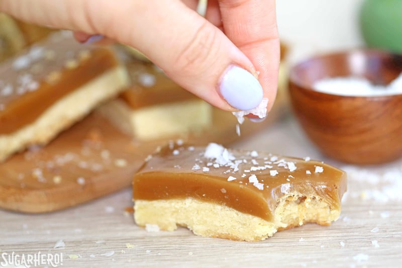 Salted Caramel Bars - buttery shortbread, soft and chewy caramel, and crunchy sea salt! | From SugarHero.com Salted Caramel Bars are perfect with a big pinch of salt on top! | From SugarHero.com