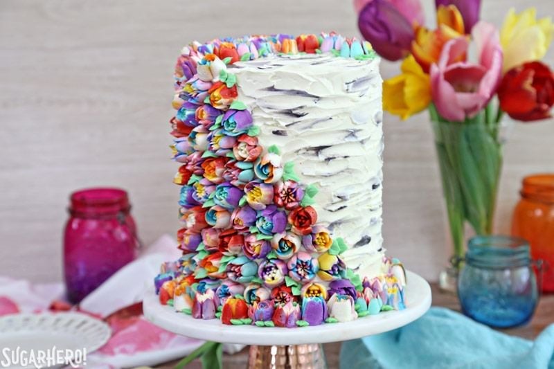 Spring In Bloom Layer Cake - an extra-tall cake COVERED in gorgeous buttercream flowers! | From SugarHero.com
