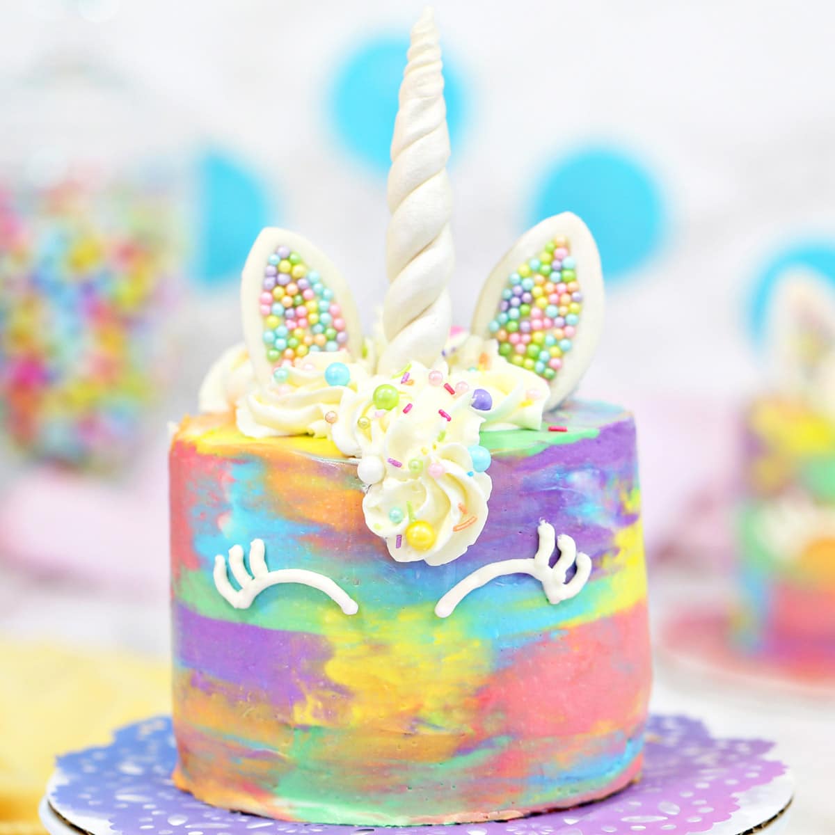 Close up of a unicorn cake on a colorful doilie.