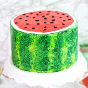 Watermelon Layer Cake on a white frilled cake platter.