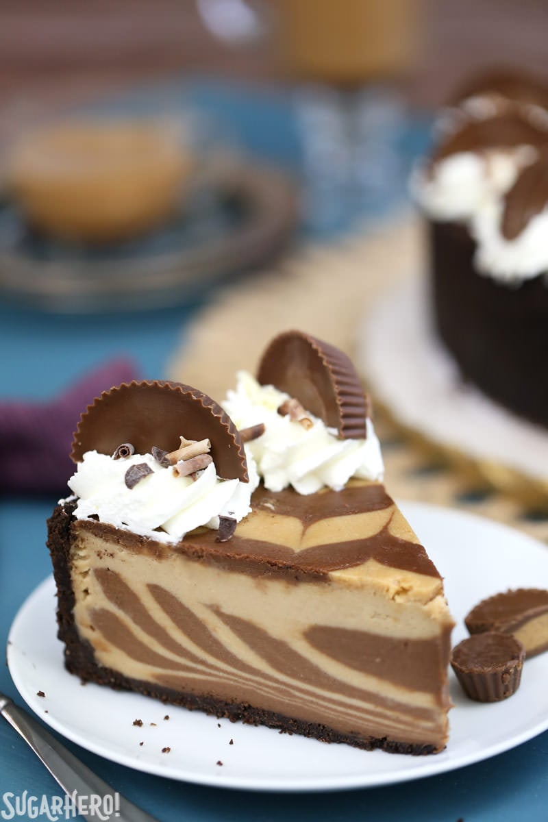Chocolate Peanut Butter Cheesecake - this is the ULTIMATE cheesecake! Smooth and creamy, with gorgeous chocolate swirls and lots of peanut butter cups! | From SugarHero.com Close-up of single slice of Chocolate Peanut Butter Cheesecake | From SugarHero.com