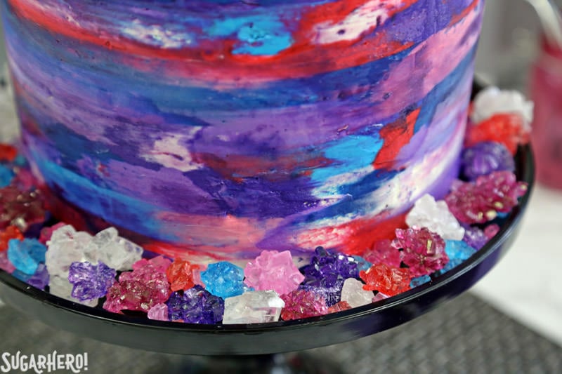 Agate Cake - with gorgeous, EDIBLE candy agate slices, and a pretty watercolor buttercream effect! | From SugarHero.com Agate Cake - close-up of the buttercream effect on the sides of the agate cake, and the rock candy that decorates the base | From SugarHero.com