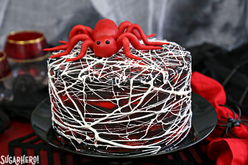 Red Velvet Marshmallow Spiderweb Cake with red candy spider on top | From SugarHero.com
