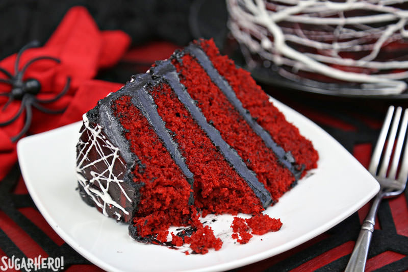 Red Velvet Marshmallow Spiderweb Cake - single slice with bite taken out of it | From SugarHero.com