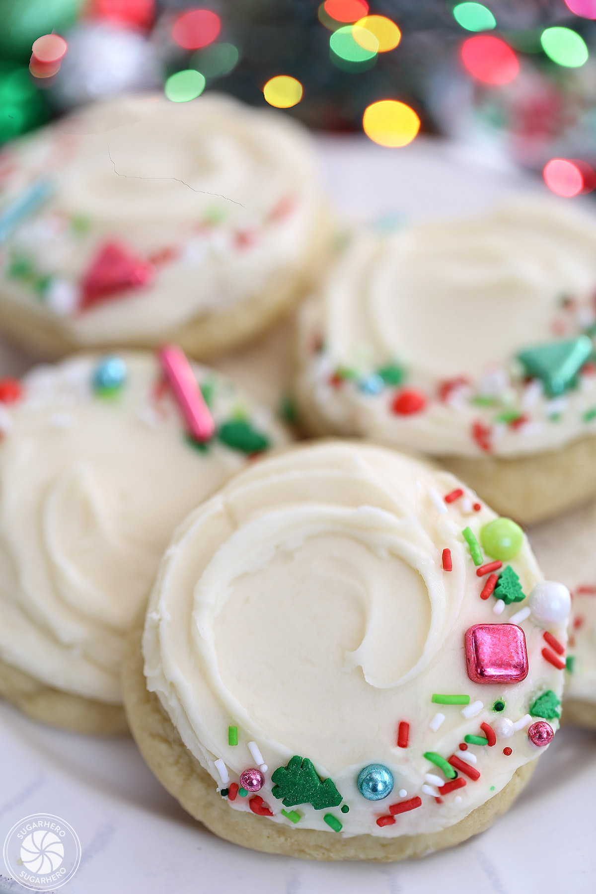 Five big soft sugar cookies on a round white plate with scalloped edges.