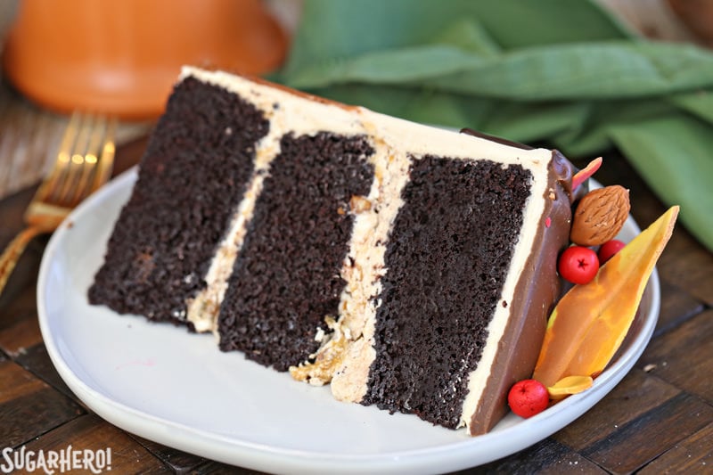 Festive Fall Layer Cake – slice of cake on a plate with fondant decorations on top | From SugarHero.com