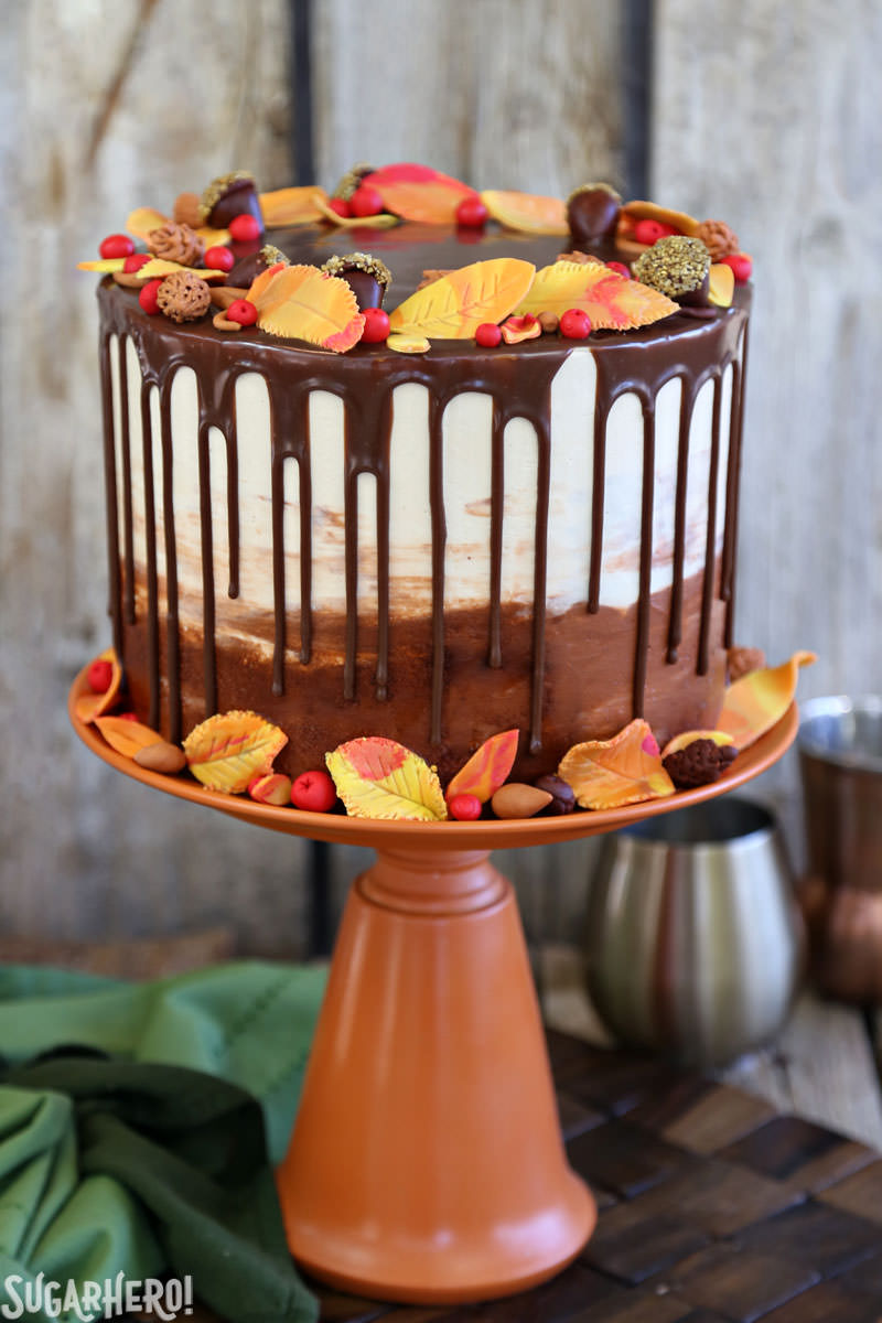 Festive Fall Layer Cake – a beautiful autumn cake! It’s a moist chocolate cake with a caramel-pecan filling, decorated with chocolate ganache drips and gorgeous, edible fall decorations! | From SugarHero.com