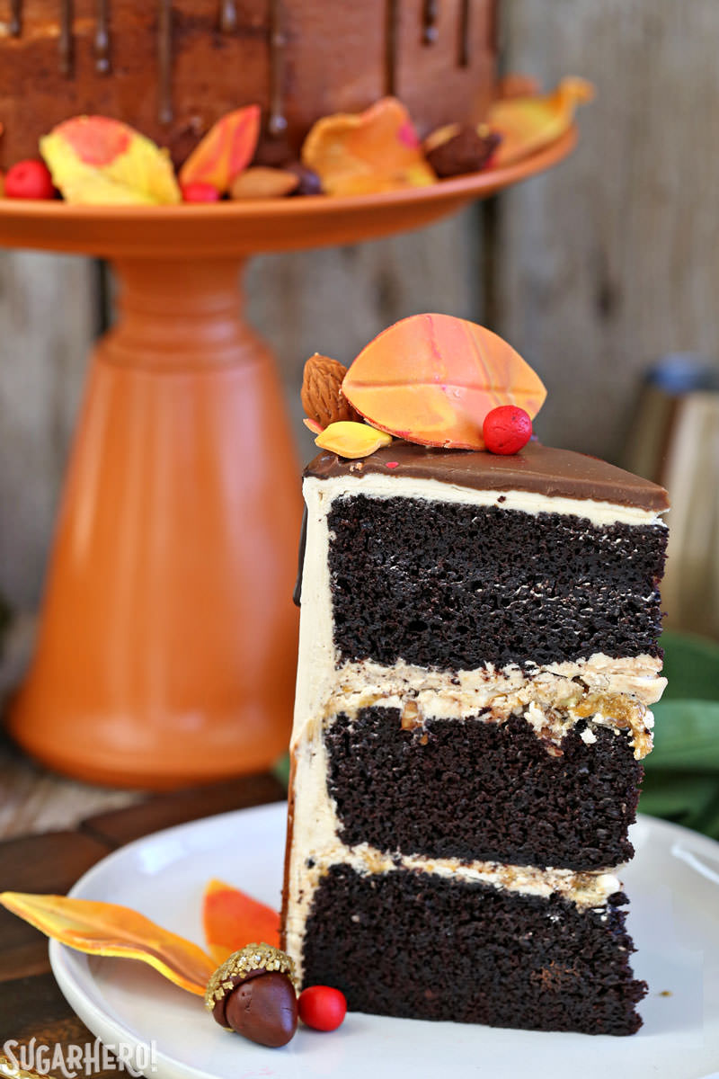 Festive Fall Layer Cake – close-up of cake slice with cake on stand in background | From SugarHero.com