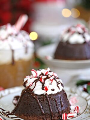 Peppermint Lava Cakes on a white plate with a peppermint mocha in the background.