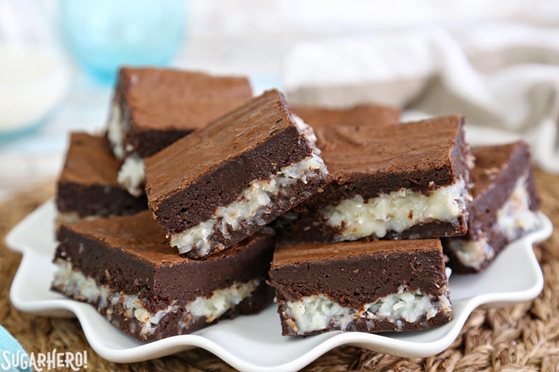 The BEST Coconut Brownies - gooey coconut brownies stacked up on a plate | From SugarHero.com