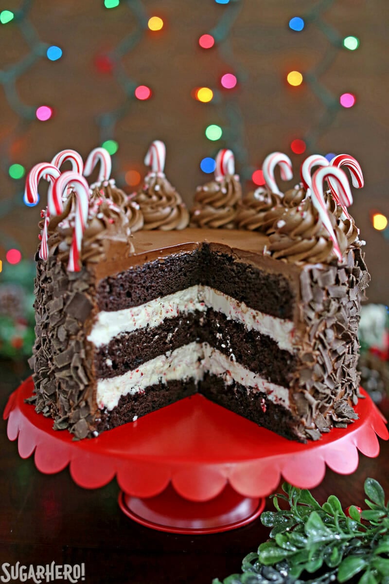 Chocolate Candy Cane Cake – the cake cut open on a red cake stand | From SugarHero.com