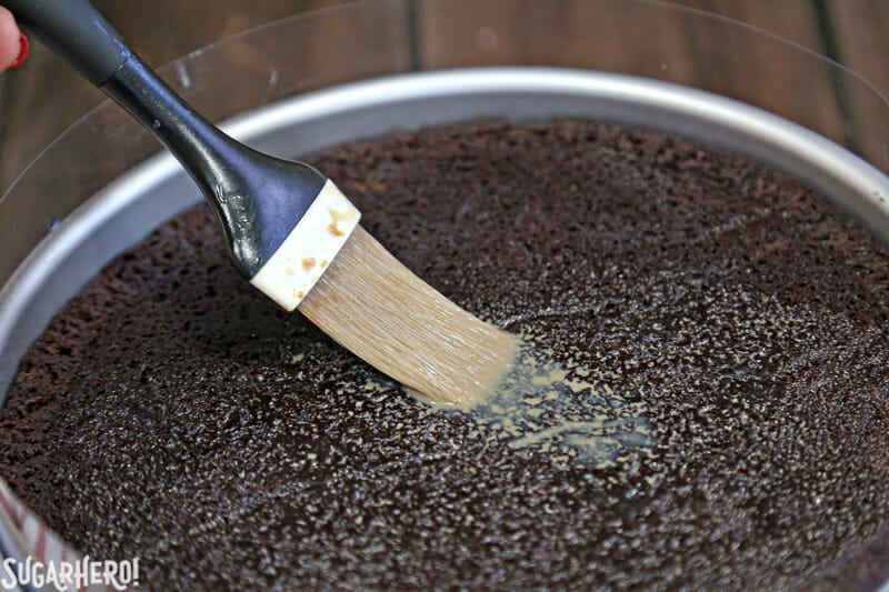 Peppermint Mocha Mousse Cake - close-up of brushing peppermint mocha cream on the mousse cake | From SugarHero.com