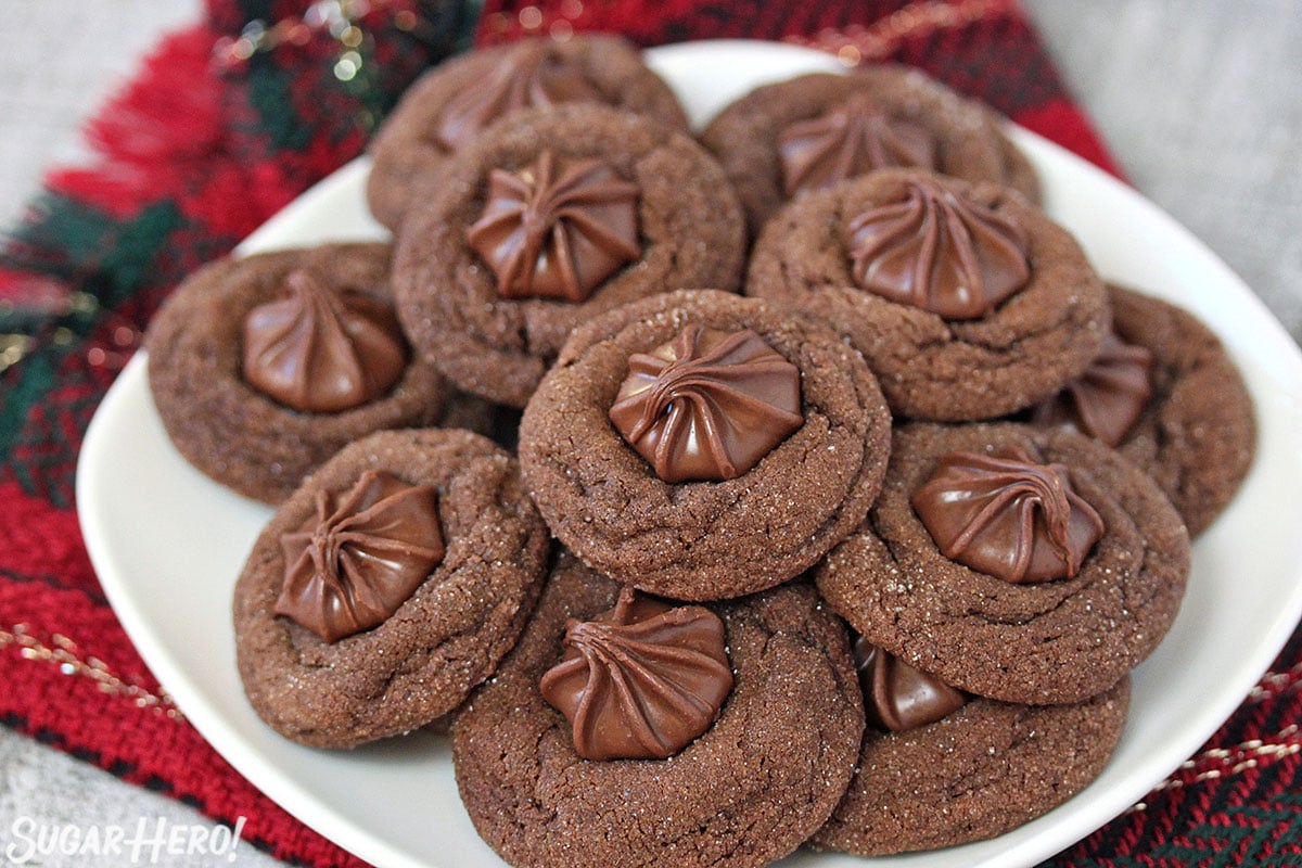 Soft Chocolate Gingerbread Cookies on a round white plate with a red and green plaid napkin in the background.
