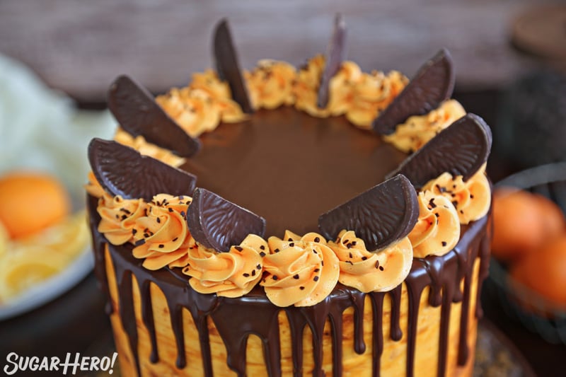 close-up of the top of the cake, with orange frosting rosettes and chocolate orange slices for decoration 
