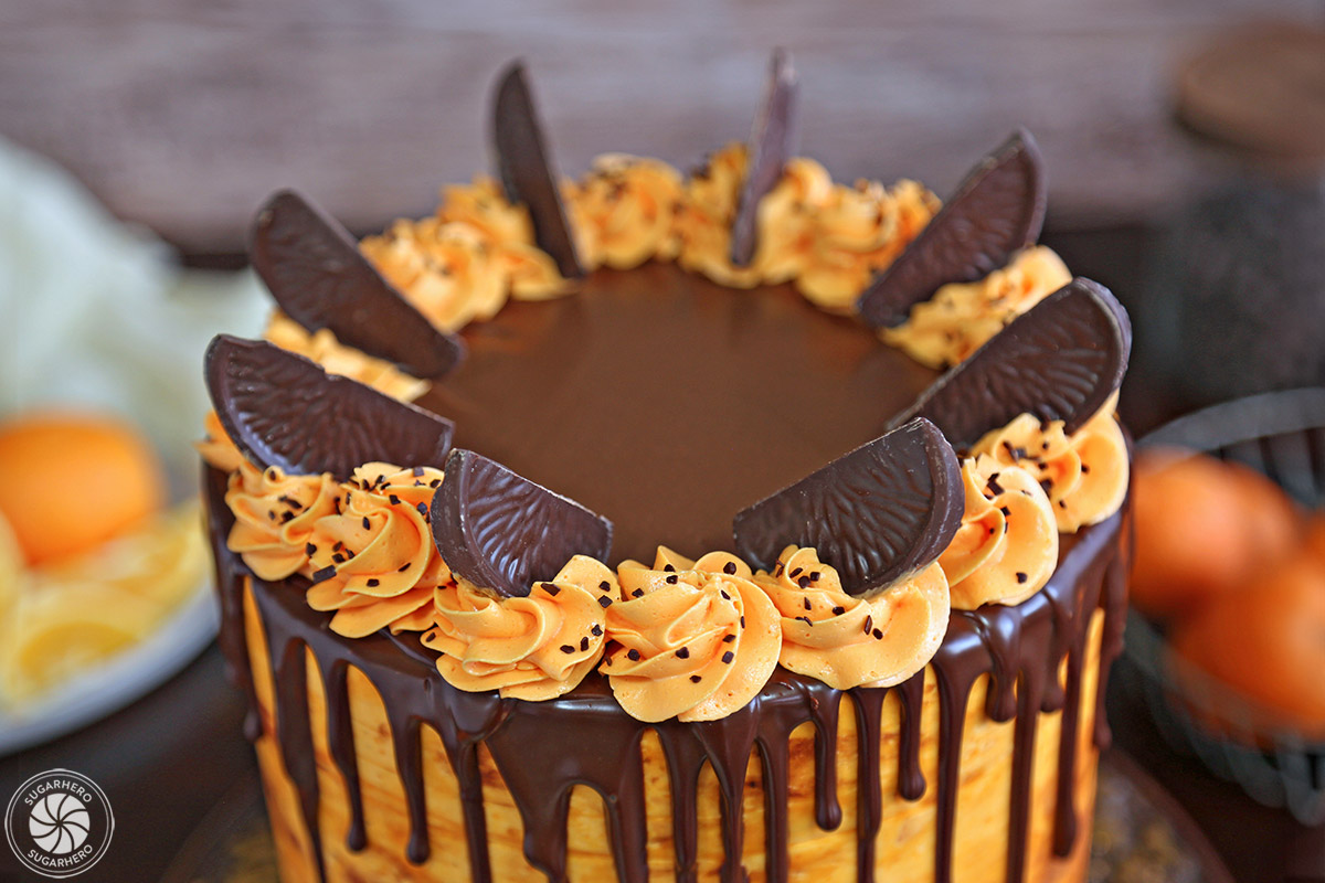 close-up of the top of the cake, with orange frosting rosettes and chocolate orange slices for decoration 