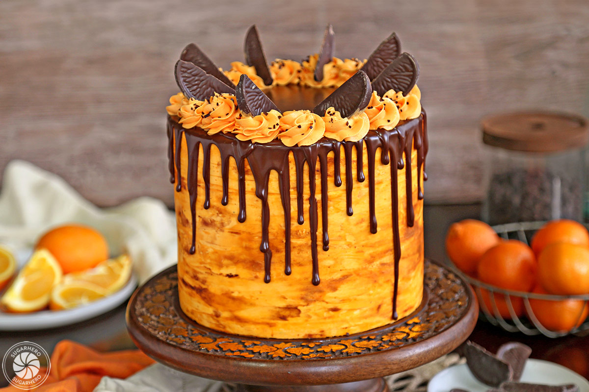 Chocolate Orange Cake on a wooden cake stand in front of a wooden background