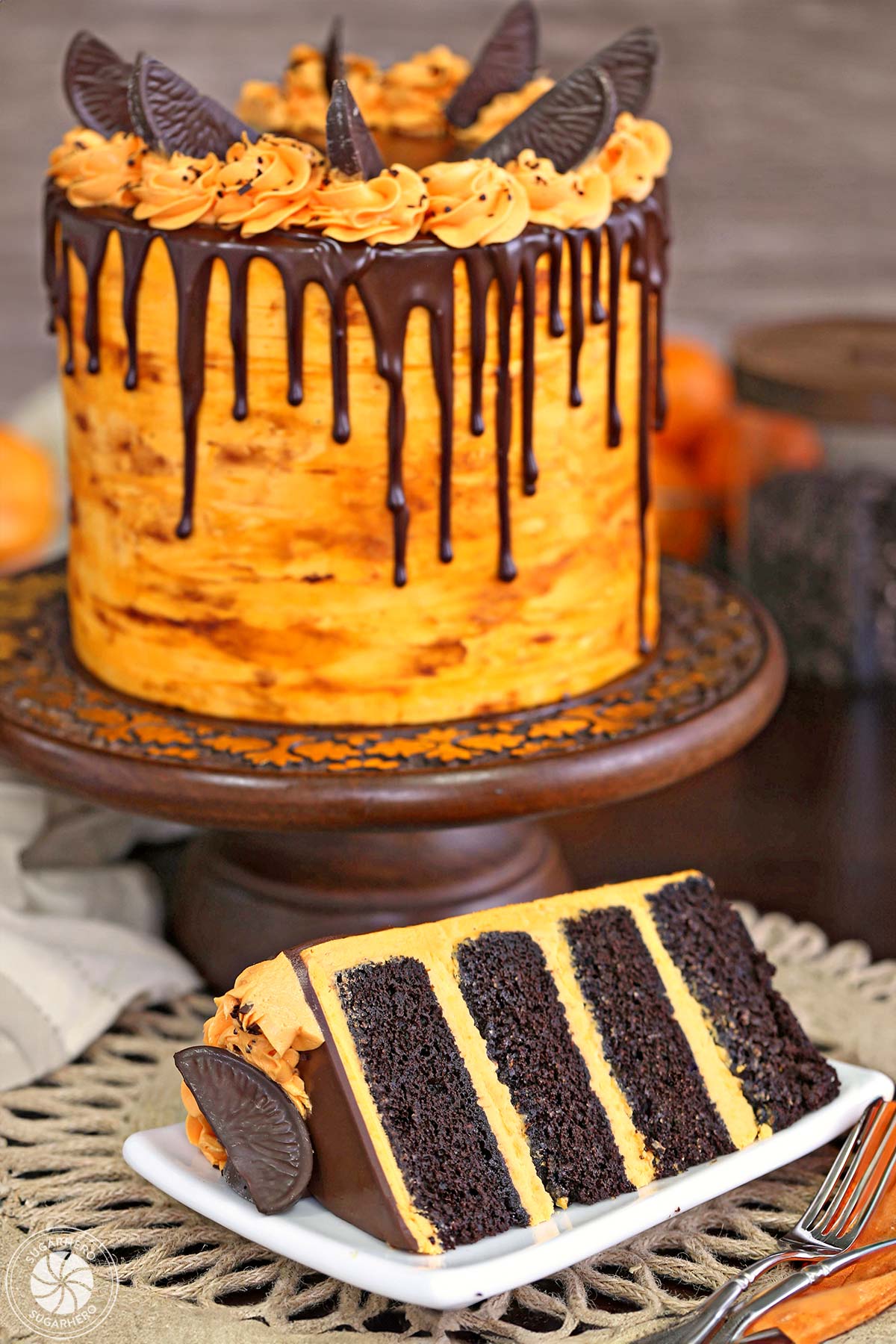 Chocolate-Orange Cake - If you love chocolate-orange flavors, this cake is for you! It's a delicious chocolate cake filled with tangy orange buttercream and topped with chocolate oranges. | From SugarHero.com picture of the chocolate cake with a slice taken out of it