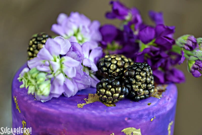 Gold Sequin Watercolor Cake - close-up of the cake topper made with fresh flowers and blackberries | From SugarHero.com
