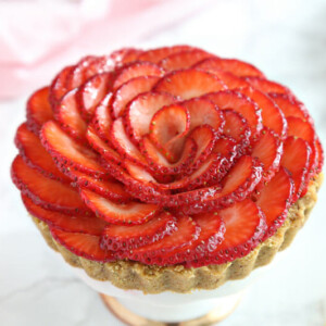 Strawberry Rose Tart on a mini cake stand with a pink napkin in the background.