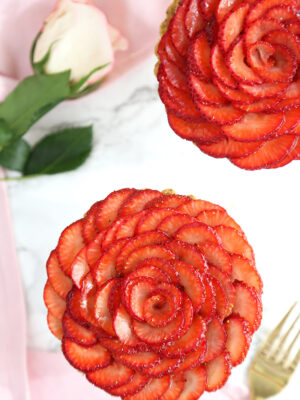 Overhead shot of two Strawberry Rose Tarts on a marble surface.