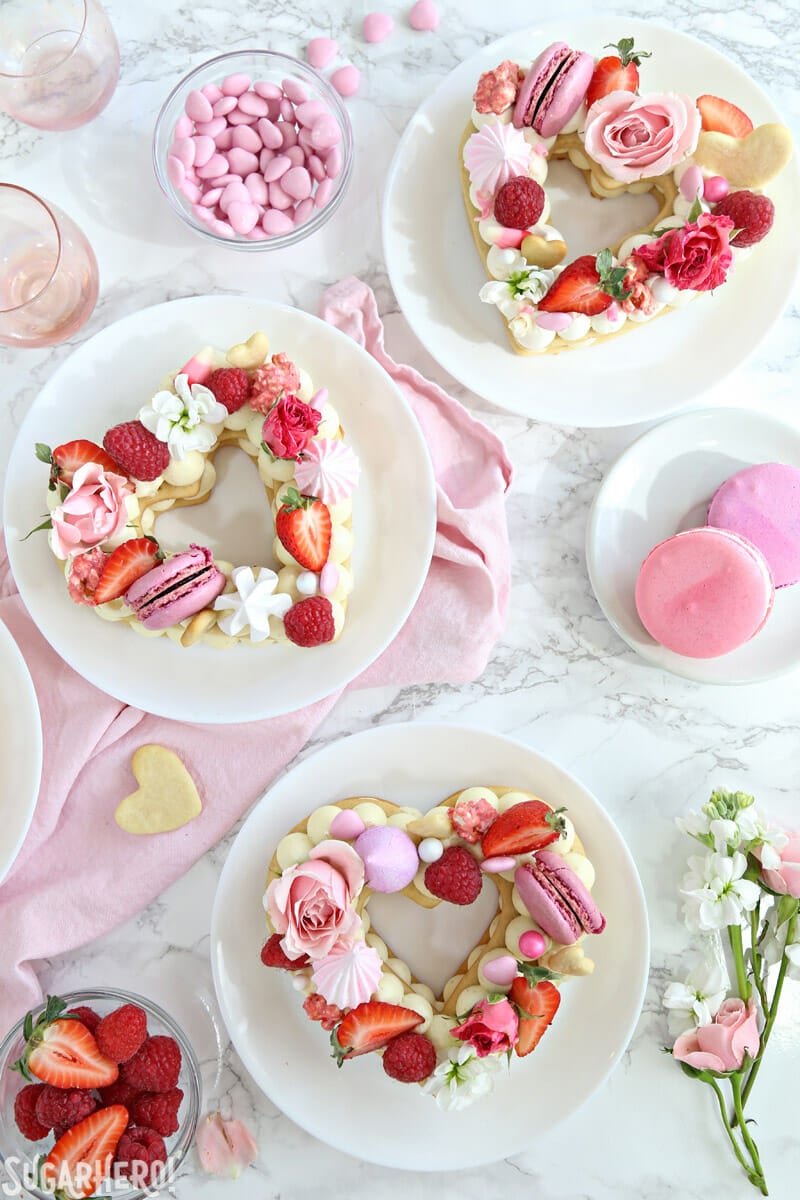 Trendy Cream Tarts are all the rage! Also known as cream biscuits or cream cakes, you can cut them into letters, numbers, or shapes, and decorate them with fruits, flowers, and candies. | From SugarHero.com Trendy Cream Tarts - overhead shot of three heart-shaped cream biscuits | From SugarHero.com
