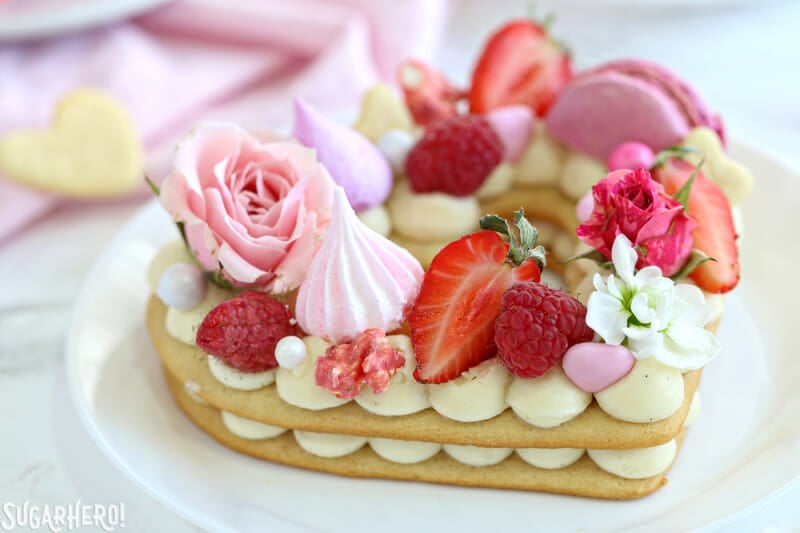 Trendy Cream Tarts -close-up shot of a single cream biscuit topped with fresh berries, meringues, flowers, and more | From SugarHero.com