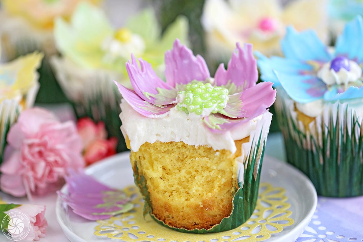 Close up of a chocolate flower cupcake with a bite missing.