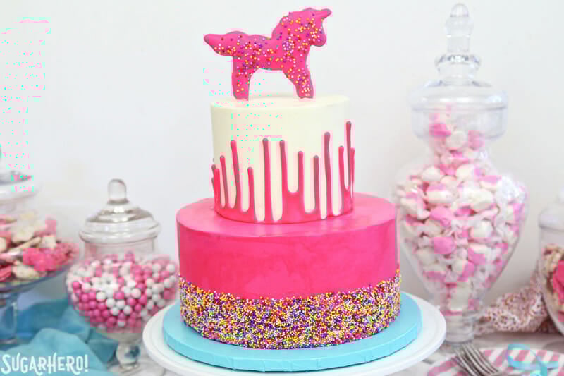 Circus Animal Layer Cake - a big, bright pink cake with funfetti cake layers, chopped up circus animal cookies inside, and a cool upside-down ganache drip decoration! | From SugarHero.com Circus Animal Layer Cake - pink sprinkled cake on bottom, white ganache drip cake on top | From SugarHero.com