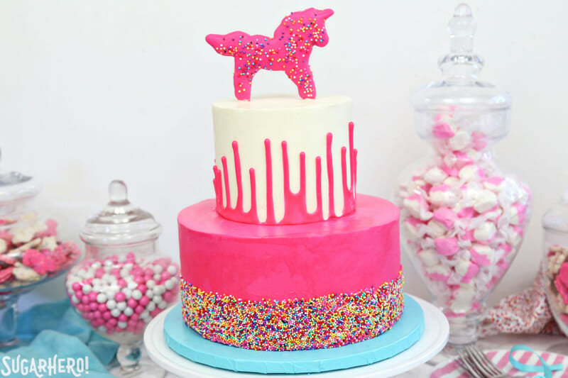 Circus Animal Layer Cake - pink sprinkled cake on bottom, white ganache drip cake on top | From SugarHero.com